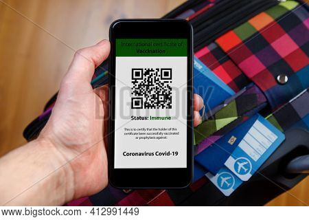 The woman holding the mobile phone a mockup for digital vaccination certificate in one hand and passport, mask and ticket in another one