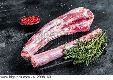 Fresh Raw Whole Beef Veal Oxtail Meat On Marble Board With Herbs. Black Background. Top View