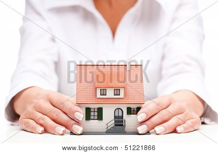 pisture of man and woman hands holding paper house