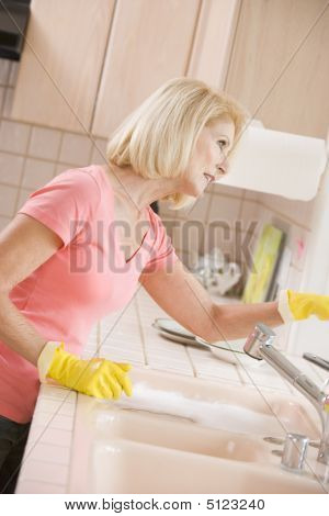 Vrouw aanrecht schoonmaken