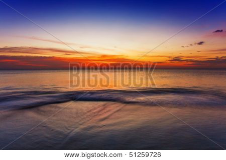 Tropical beach in ebb time on sunset background