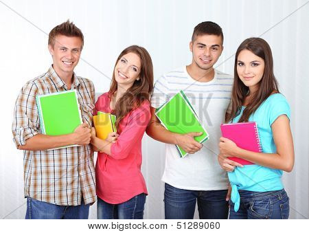 Group of happy beautiful young students at room