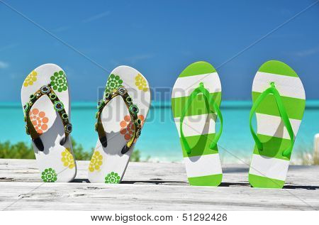 Two pairs of flip-flops against Atlantic. Exuma, Bahamas