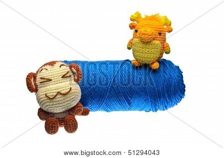 Crochet Monkey And Dragon And Blue Yarn On Isolated White Background