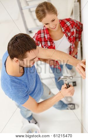 repair, building and home concept - smiling couple renovating new home