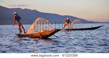 INLE LAKE, MYANMAR DECEMBER 12, 2013: Fishermen at Inle Lake, Shan State, Myanmar Intha people possess the leg-rowing style and the unique coop-like fishing equipment