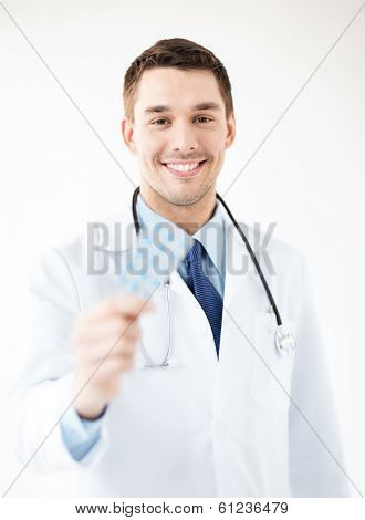 picture of young male doctor with pack of pills