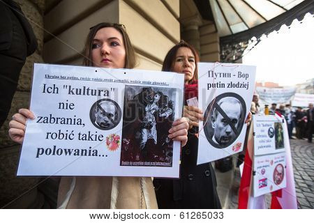 KRAKOW, POLAND - MAR 9, 2014: Unidentified participants during protest near Cracow Opera, against bringing Russian troops in the Crimea. Posters: Ukraine without Putin, and Putin - Thief.