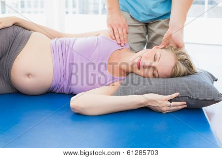 Blonde pregnant woman having a relaxing massage in a studio
