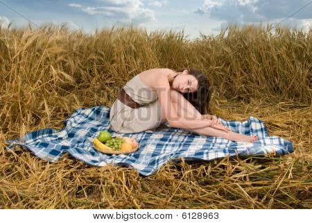 Beautiful girl on picnic in wheat field