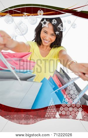 Highangle view of a young woman showing shopping bags against christmas frame