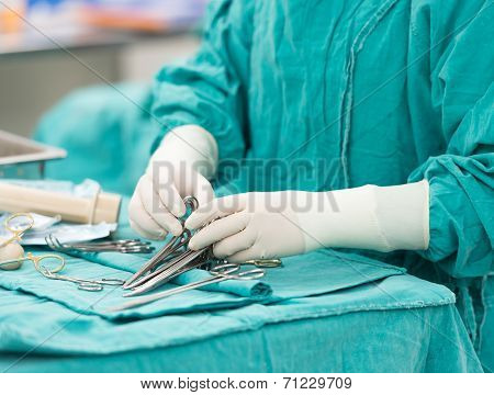 Scrub Nurse Preparing Tools For Operation
