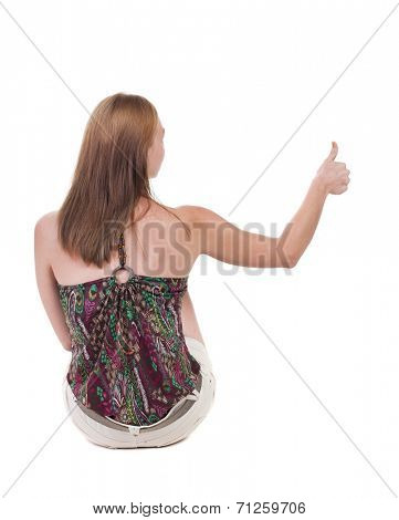 back view of siting young blonde  woman showing thumb up.  Rear view people collection.  backside view of person.  Isolated over white background