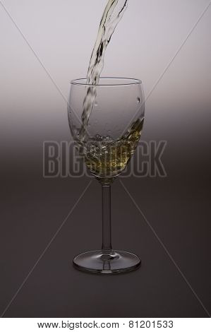 White wine being poured into clear wine glass