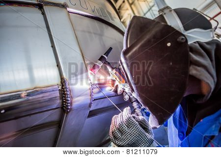 Man welding with reflection of sparks on visor. Hard job.