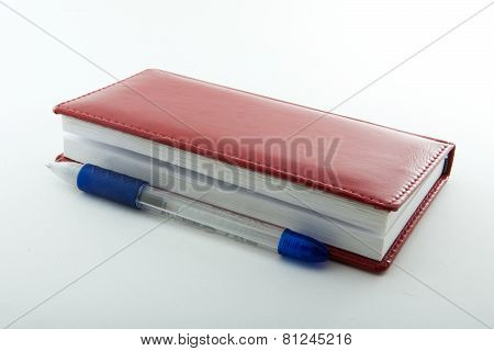 Plastic Pen And Red Notebook