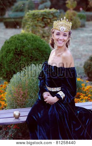 Smiling Young Woman Dressed Like Queen Holding An Apple