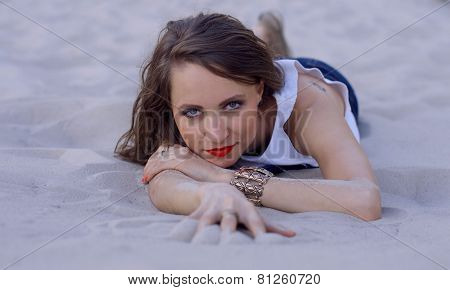 Young woman lying on the sand
