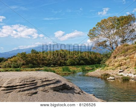 River with background of the volcano Etna