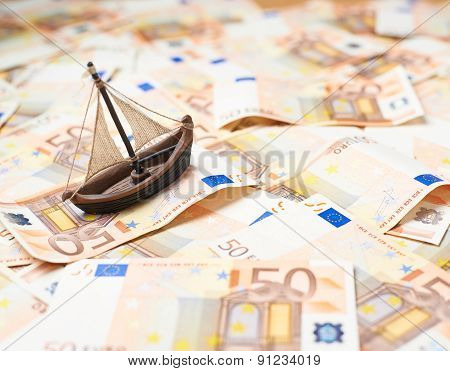 Tiny ship over the bank note bills