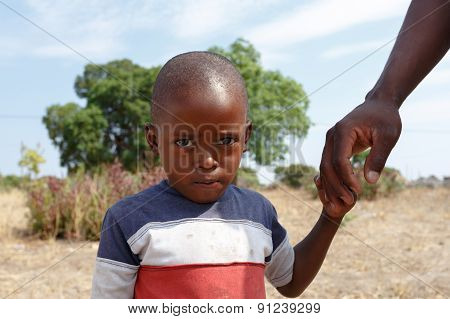 Portrait Of Namibian Small Boy With Fathers Hand