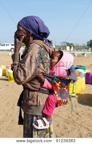 Small Namibian Child On The Back Of His Mother