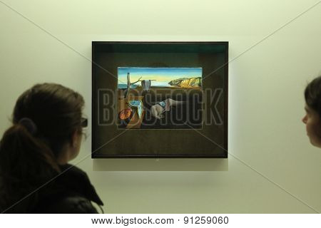 PARIS, FRANCE - JANUARY 7, 2013: Visitors look at the painting The Persistence of Memory (1931) by Salvador Dali displayed at his retrospective exhibition in Paris, France. 