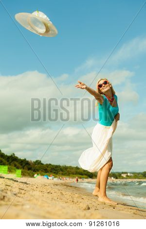 Girl Trowing Hat Up On Beach