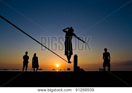 Silhouette of young man balancing on slackline at a beach in Manabi, Ecuador