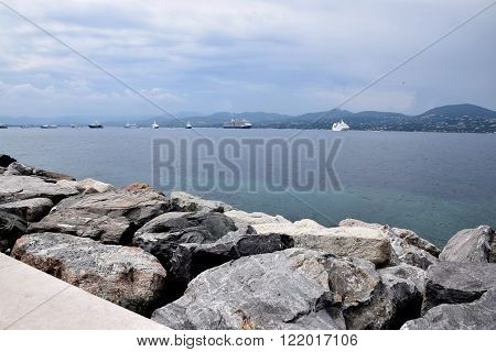 Sea in Saint-Tropez with stones and boat on horizont