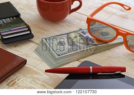 a bundle of money and other items on the table