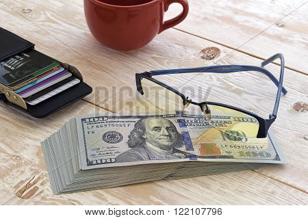 a bundle of money and other items on the table