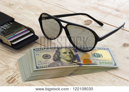 a bundle of money and other items on the table