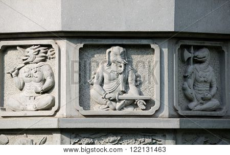 Various animal gods on a stone buddhist prayer pillar at Zhenru Temple in Shanghai China.