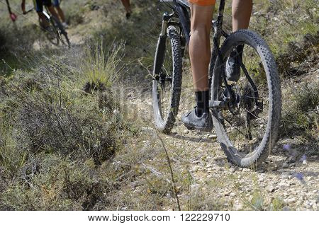 Low angle view of cyclist riding mountain bike on rocky trail, BTT