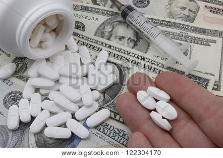 Showing 4 pills with Injection syringe US Dollars and pills in the background.