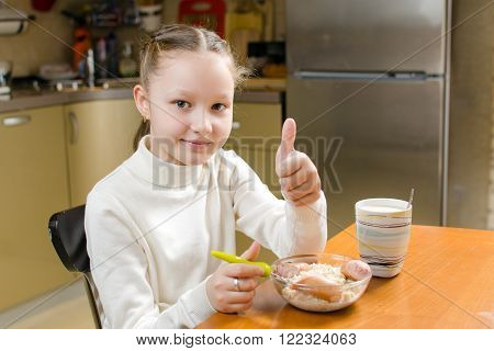 Little girl eating breakfast in the kitchen before going to school
