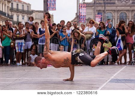 Montpellier, France - July 12: Street performer breakdancing on main square in front of the random crowd on July 12, 2011 in Montpellier, France.