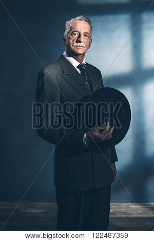 Retro 1940 Senior Businessman Holding Hat Standing In Room.