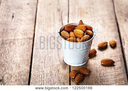 Roasted grains of peanuts in a wooden bucket isolated on white background, tasty food