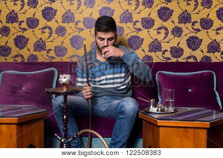 Man Smoking Shisha And Drinking Coffee