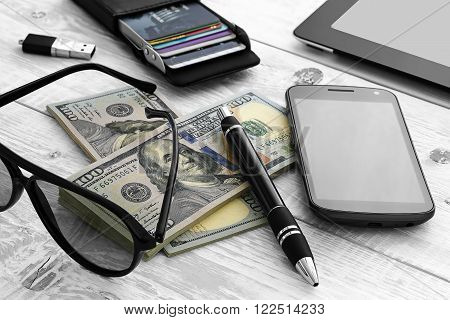 a bundle of money and other items on the table