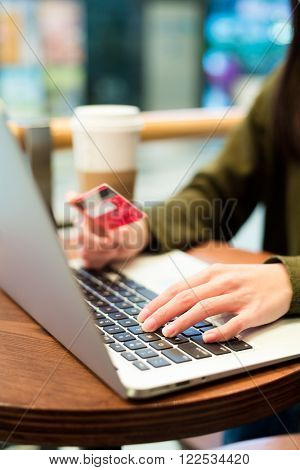 Woman typing on laptop computer for online shopping