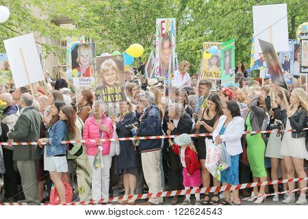 STOCKHOLM, SWEDEN - JUN 10, 2015: Relatives to the graduating teenagers waiting outside school with funny posters at the school Globala gymnasiet, June 10, 2015, Stockholm, Sweden