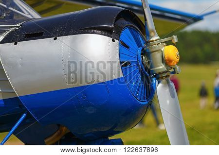 Engine and propeller of blue airplane. Close-up of a single-engine plane fuselage. Fragment of the aircraft.