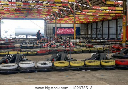 O'CONNOR,WA,AUSTRALIA-MARCH 5,2016: Indoor Kart Hire racing with go karts and colourful tire boundaries with people in O'Connor, Western Australia.