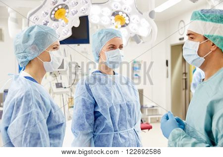 surgery, medicine and people concept - group of surgeons in operating room at hospital