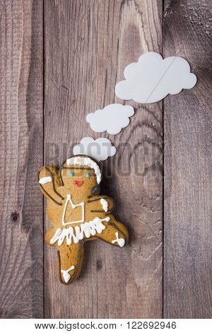 Gingerbread man in the form of a dancer on a wooden table