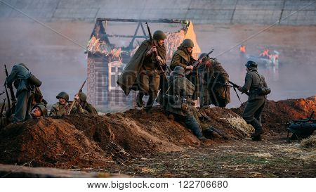 MOGILEV, BELARUS - MAY 08, 2015: Reconstruction of battle for liberation of Mogilev. Reenactors dressed in uniform of World War II Soviet and German soldiers are fighting hand to hand over trenches.