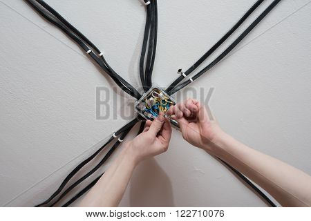 Installation of the electrical junction box on the ceiling of the apartment. Wiring of electrical power wires